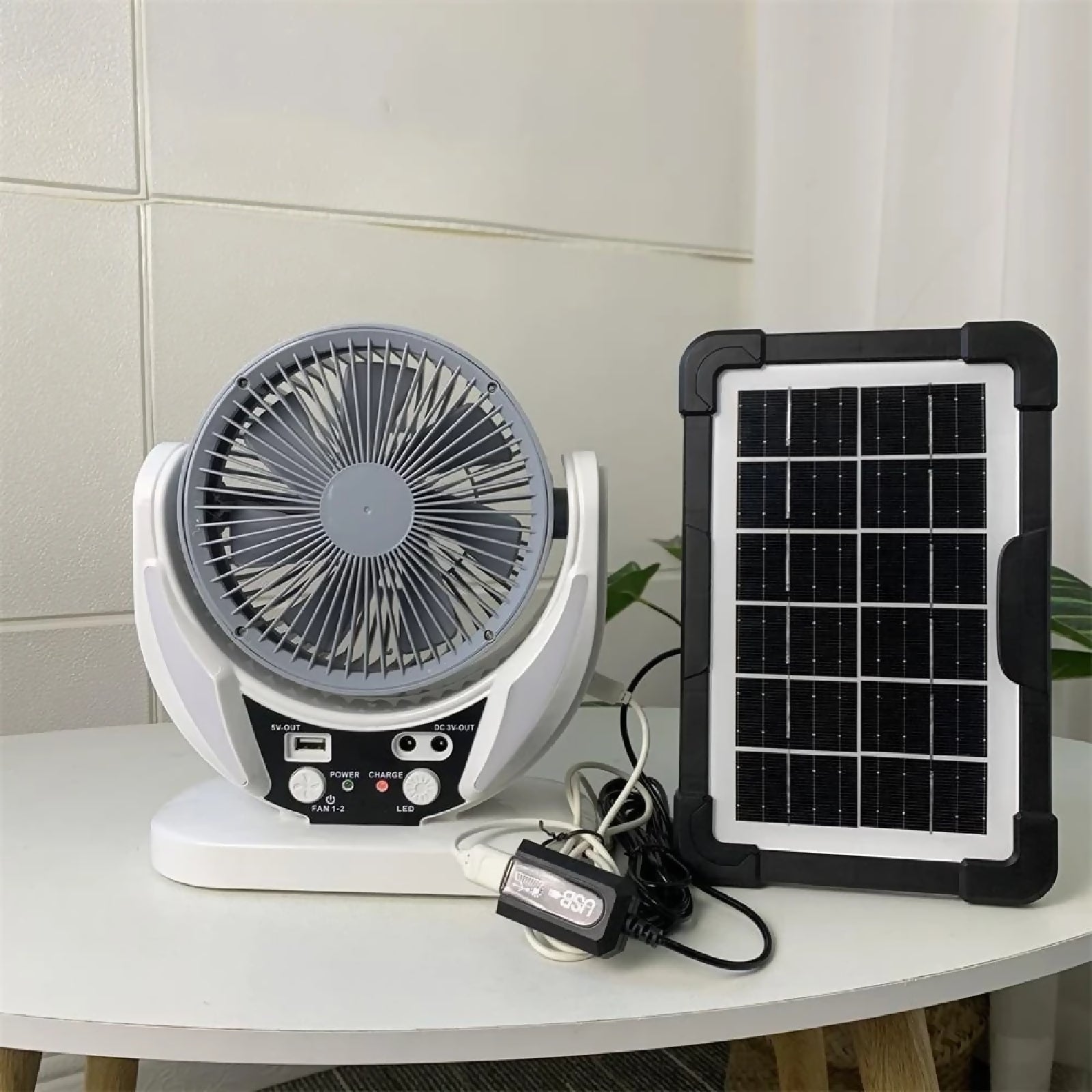 Portable fan with solar panel on a white surface