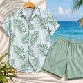 A men's two-piece casual beach outfit featuring a short-sleeve button-up shirt with a green palm leaf pattern on a white base, and matching sage green drawstring shorts, displayed against a tropical beach background.
