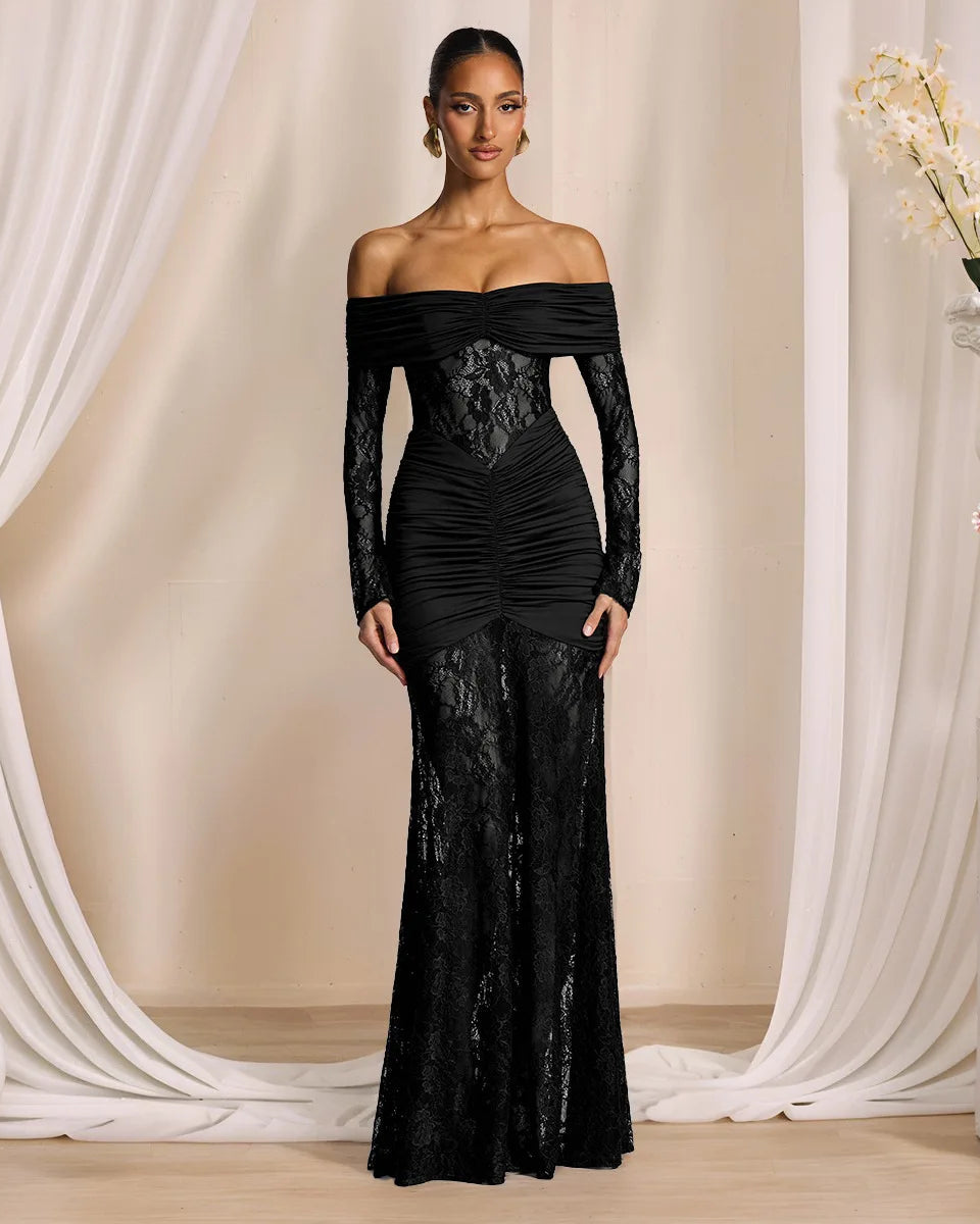 Woman wearing a black lace evening gown in a elegant indoor setting with floral decorations.