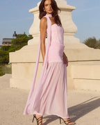 Woman in a pink dress standing in front of classical architecture