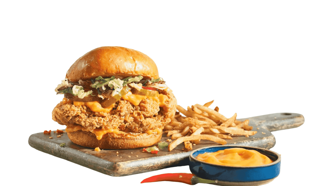 Chicken sandwich with fries and sauce on a wooden board. Town Bakery Crispy sandwich