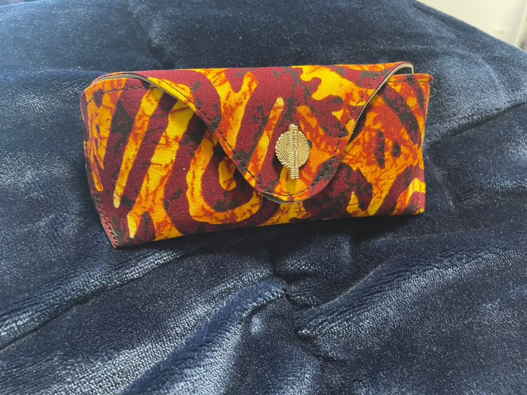 Colorful patterned clutch bag on a dark blue denim surface