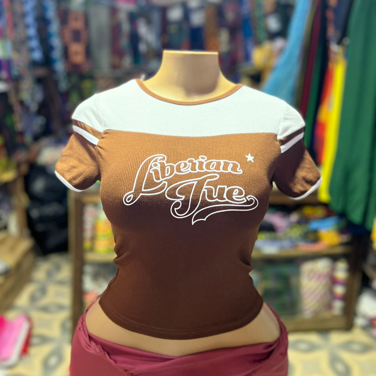 Mannequin wearing a brown and white shirt with 'American True' text in a store setting