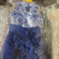 Blue dress with floral pattern on a hanger, partially covered by clear plastic.