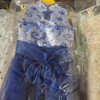 Blue dress with floral pattern on a hanger, partially covered by clear plastic.