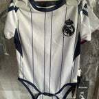 White and navy striped baby onesie with Real Madrid logo on a hanger.