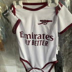 Baby onesie with Emirates logo and text on a hanger