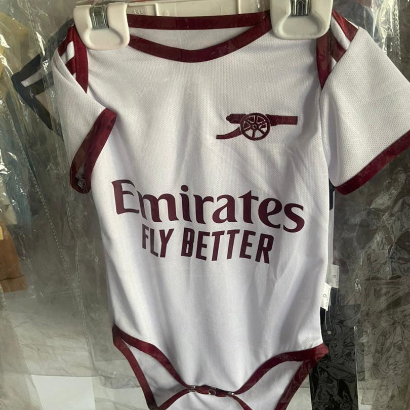 Baby onesie with Emirates logo and text on a hanger