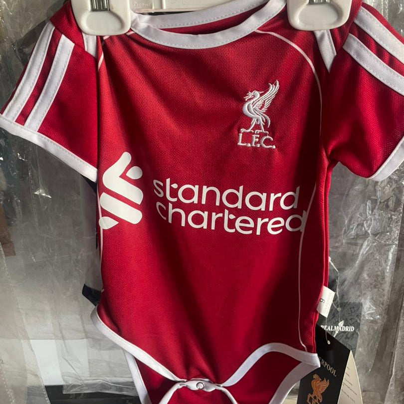 Red baby onesie with white accents and visible branding on a hanger.