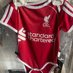 Red baby onesie with white accents and visible branding on a hanger.