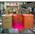 Perfume bottles and packaging displayed on a screen with a beige background