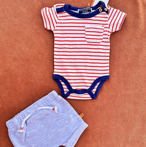 Striped baby bodysuit and shorts set on a brown surface