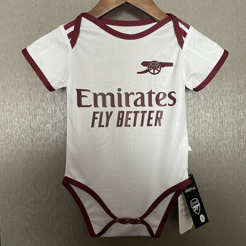 Baby onesie with Emirates branding on a hanger against a neutral background