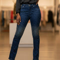 Navy blue pants with star pattern and red stripe on a textured floor.