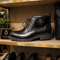Black leather boot on a shelf with a 'Premium Collection' sign in the background