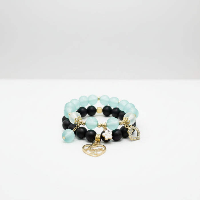 Beaded bracelet with black, blue, and gold beads on a reflective surface