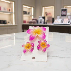 Colorful flower-shaped hair clips on a white card with a blurred background