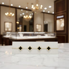 Bracelet with clover-shaped charms on a clear card with brand name.
