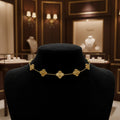 Gold bracelet on a clear plastic card with brand name, on a reflective surface.