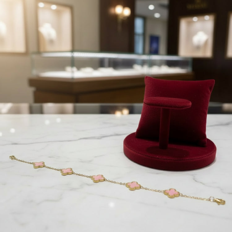 Bracelet with pink flower-shaped charms on a reflective surface