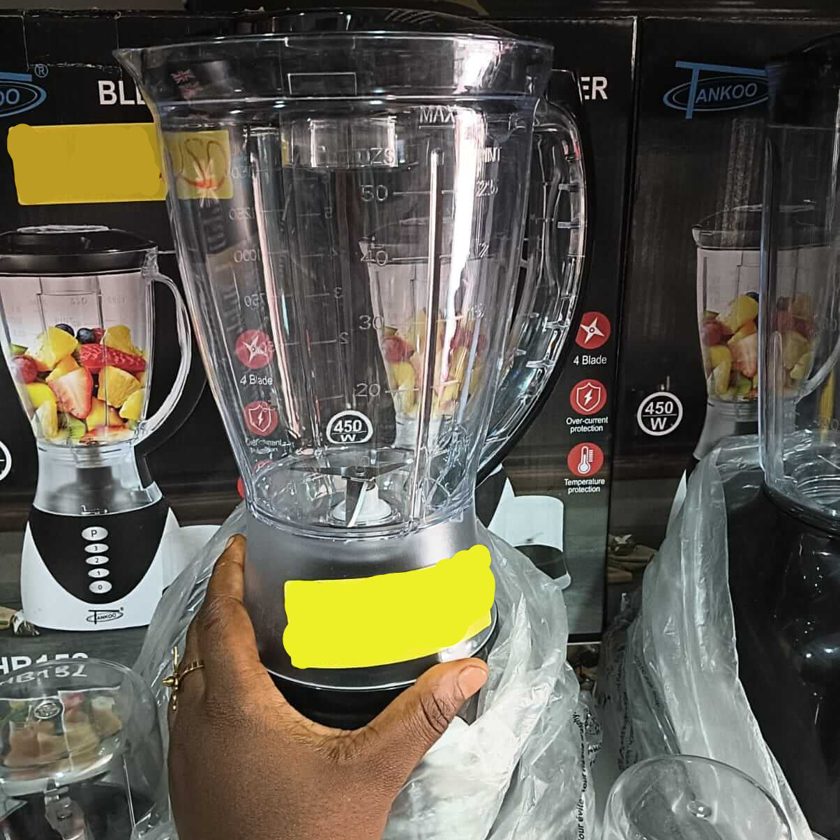 Hand holding a blender with a price tag in a store setting