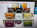 Display of various handbags in different colors on a shelf.