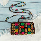 Colorful handbag with patterned design on a light blue wooden surface
