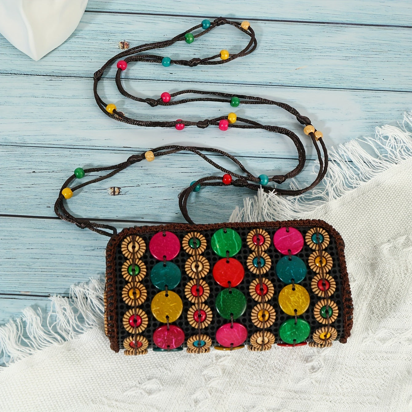 Colorful handbag with patterned design on a light blue wooden surface