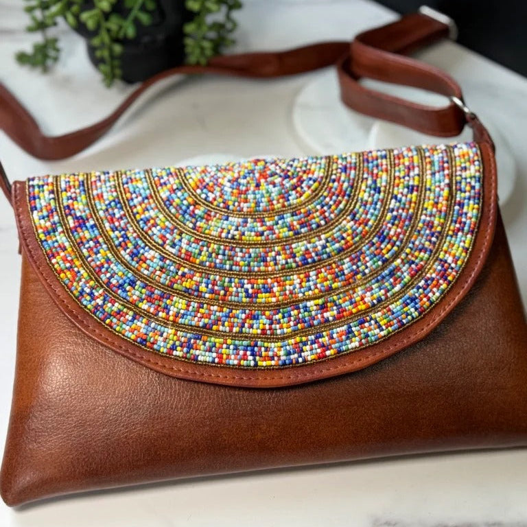 Brown handbag with colorful bead design on a marble surface