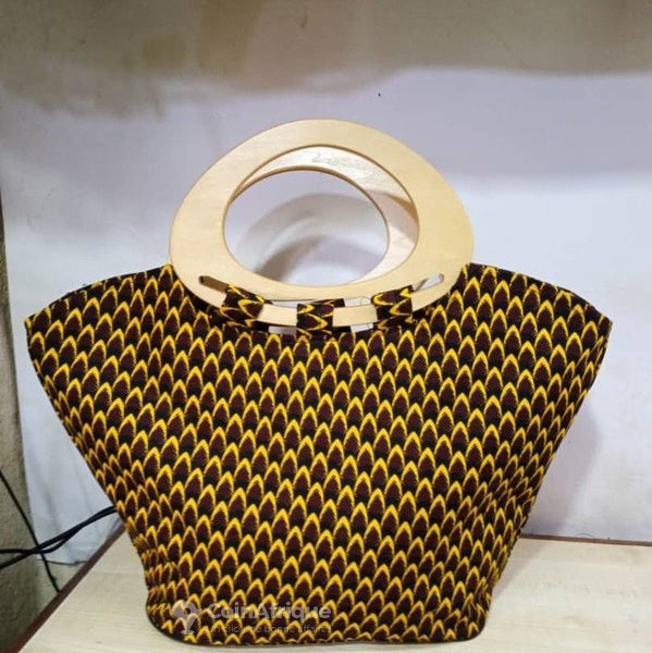 Black and yellow patterned handbag with wooden handle on a white background