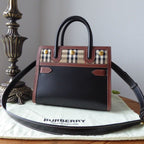 Burberry handbag on a branded mat with a decorative lamp in the background