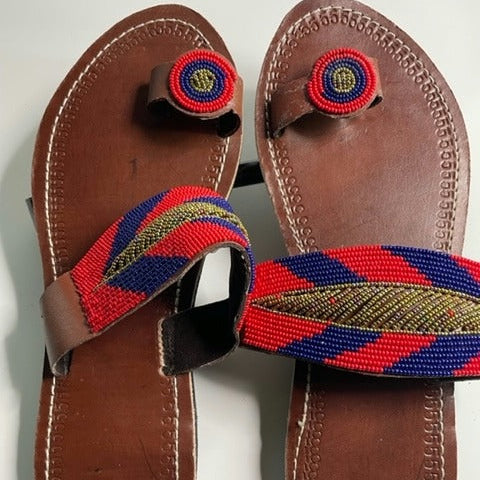 Pair of brown sandals with colorful straps on a white background