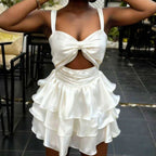 Woman wearing a white dress with a bow detail in an outdoor setting
