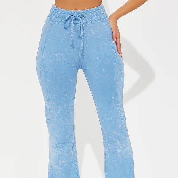 Light blue denim pants with a drawstring waist on a white background