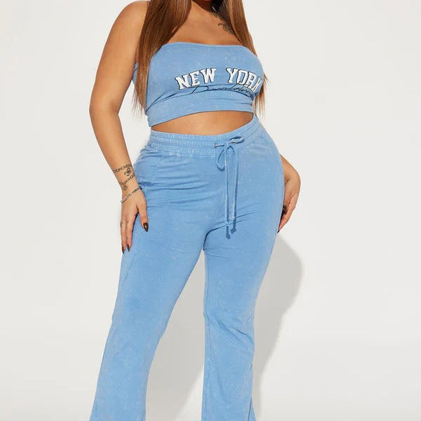 Woman wearing a blue 'New York' top and matching pants on a white background