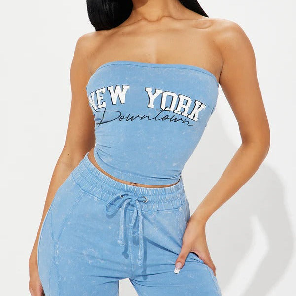 Woman wearing a blue 'New York Down town' strapless top and matching pants on a light gray background