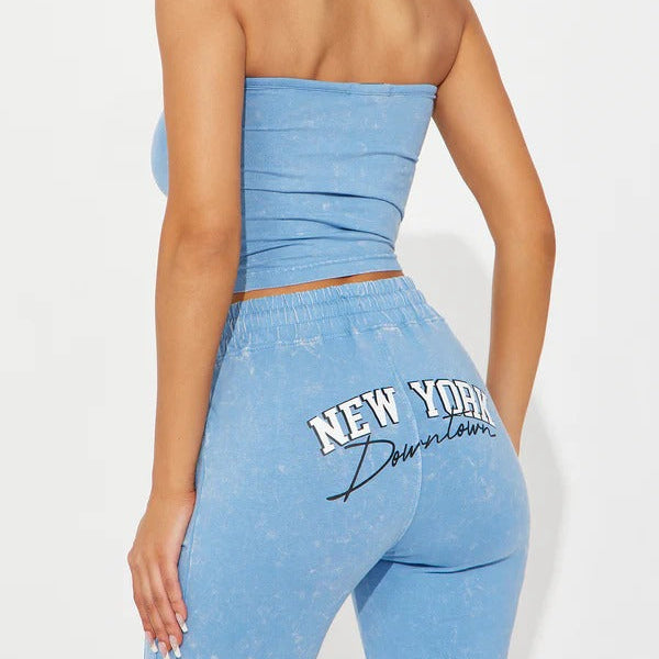 Woman wearing a blue strapless top and leggings with 'New York' text on a white background