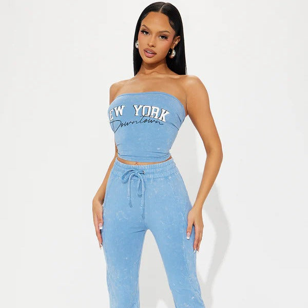 Woman wearing a blue 'New York' top and pants on a white background