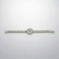Silver bracelet with clear stones in packaging on a reflective surface
