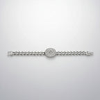 Silver bracelet with clear stones in packaging on a reflective surface