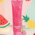 Hand holding a pink tube with a matching keychain on a reflective surface.