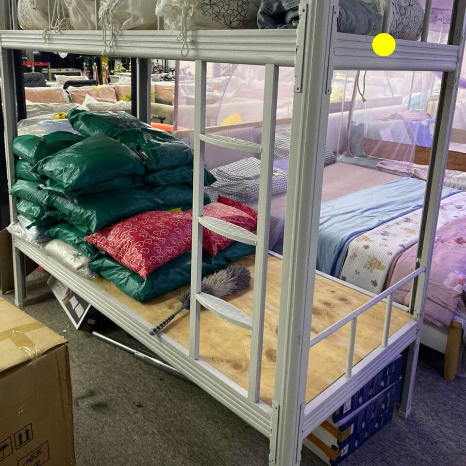 Bunk bed with mattresses and bedding in a storage or warehouse setting