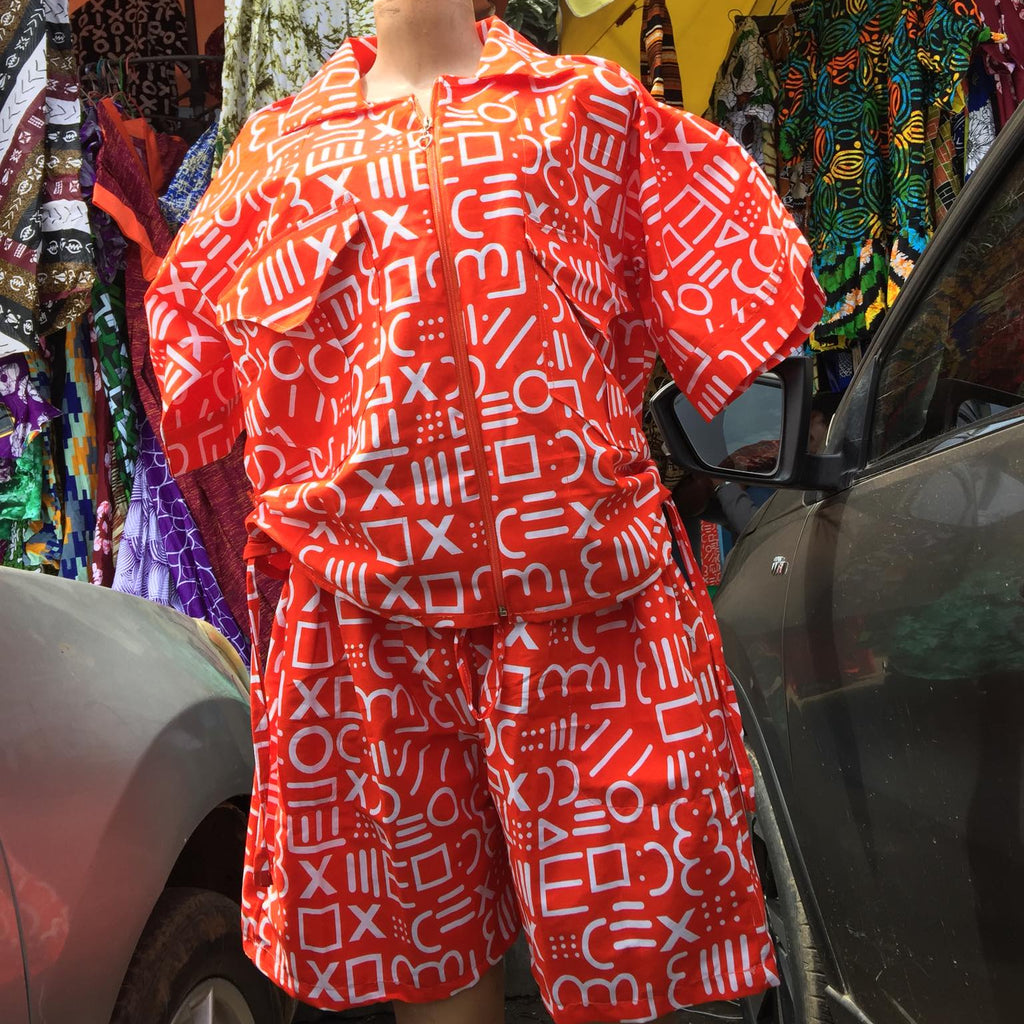 Red and white patterned outfit on a mannequin in an outdoor market setting.