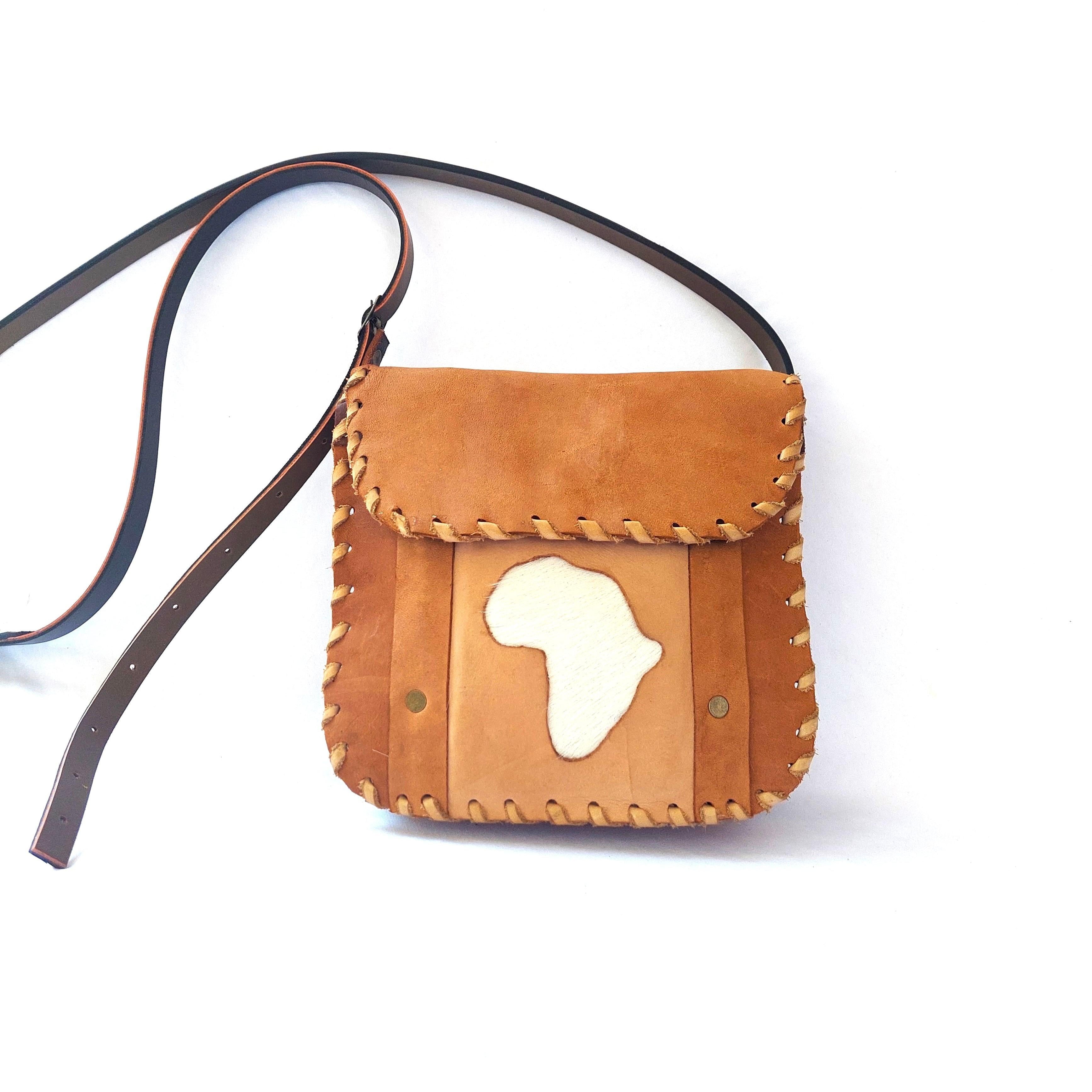 Brown leather crossbody bag with Africa cutout design on a white background