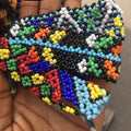 Colorful beaded pattern held in a hand with 'SOD' text above.