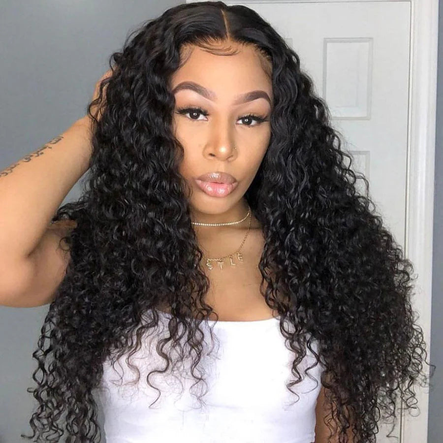 Woman with long, curly black hair wearing a white top against a neutral background
