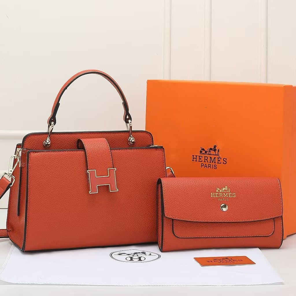 Orange Hermes handbag and matching pouch with orange box on a white background