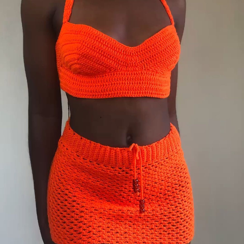 Person wearing an orange crochet bikini set against a neutral background