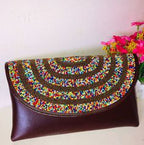 Brown clutch bag with colorful beaded design on a white background