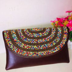 Brown clutch bag with colorful beaded design on a white background